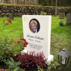 Installed Peaceyard® customer headstone, model Ada. Material color Glacier White med uttonad bild, muslimska symboler samt standard sockel Picture of Installed customer headstone, Glacier White Peaceyard® Ada