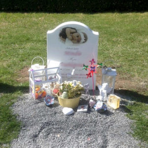 picture of installed peaceyard upright gravestone, model cora in glacier white color with customer graphics