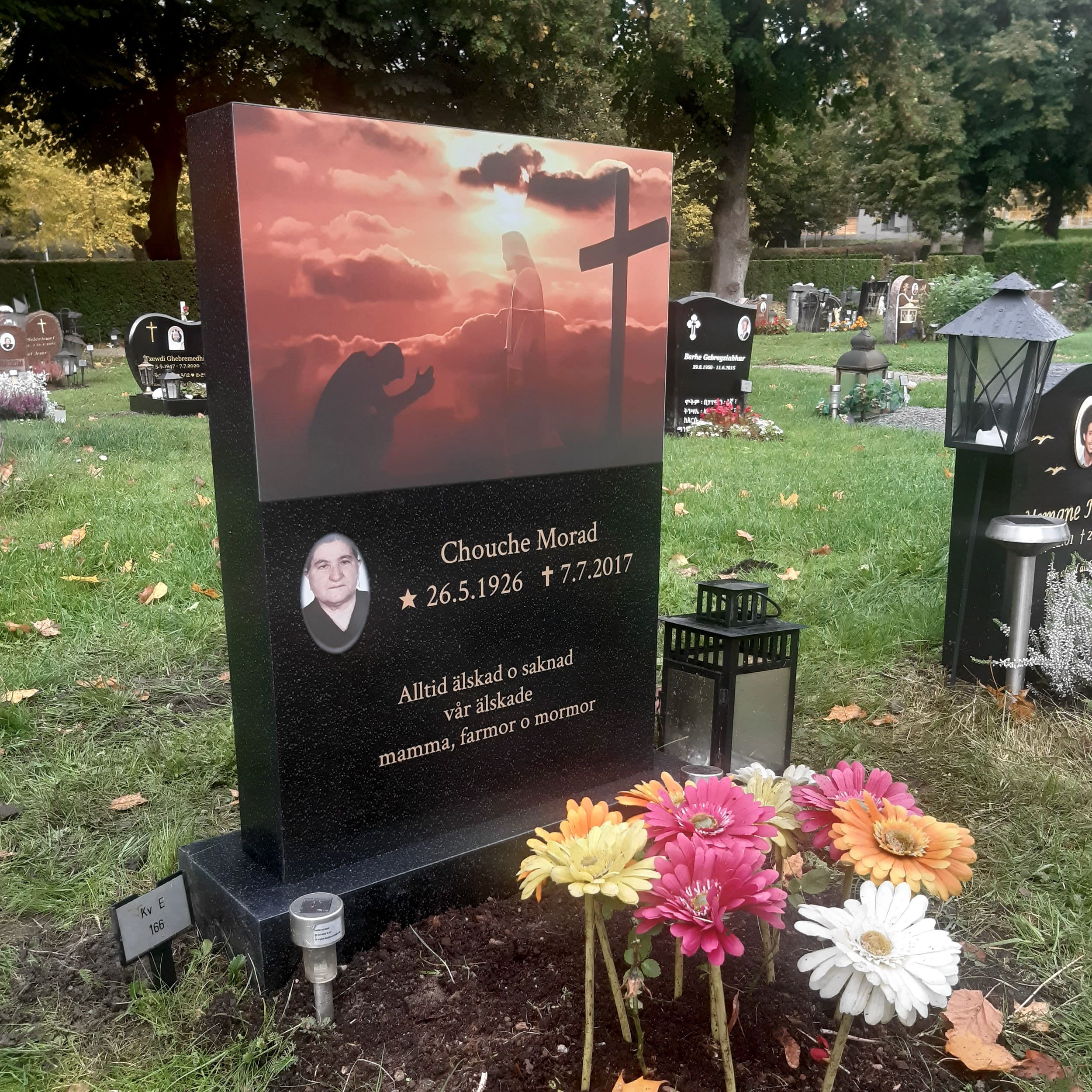 picture of installed peaceyard upright gravestone, Ada in Night Sky material with customer graphics