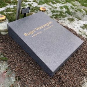 picture of installed peaceyard horizontal gravestone, model Flora in Midnight material with customer graphics